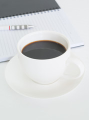 Coffee cup with note book and pencil