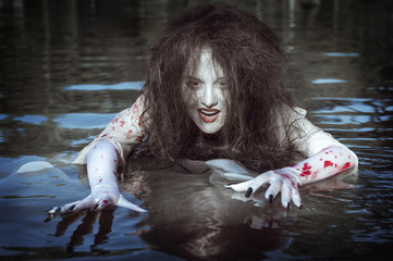 Witch woman dressed white bloody shirt the river