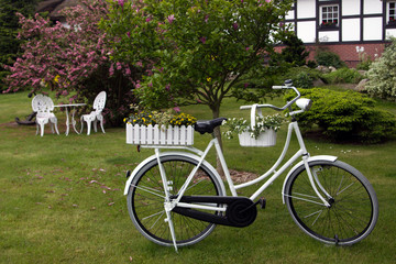 Fototapeta premium Fahrrad mit Blumenkästen und Blumen im Garten