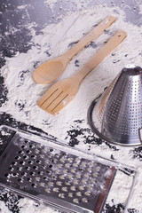 kitchen utensils on wood covered in flour