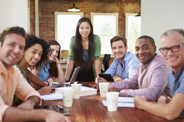 Portrait Of Female Boss With Team In Meeting