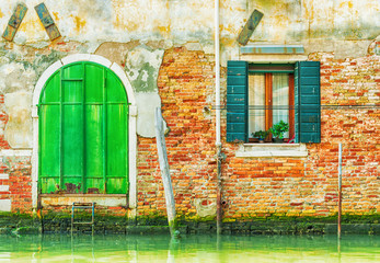 Old green iron door over a canal in Venice, Italy.