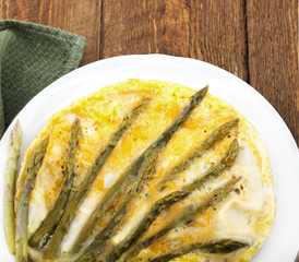 Omelet with asparagus on a wooden table.