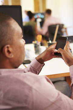 Businessman Using Mobile Phone In Creative Office