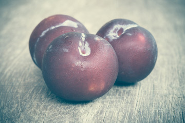 plums on wood background with filter effect retro vintage style