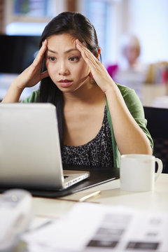 Stressed Woman Working At Laptop In Contemporary Office