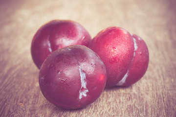 plums on wood background with filter effect retro vintage style