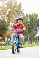 Fototapeta premium Young Boy Riding Bike In Park