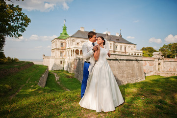 Obraz na płótnie Canvas Young wedding couple on background old castle