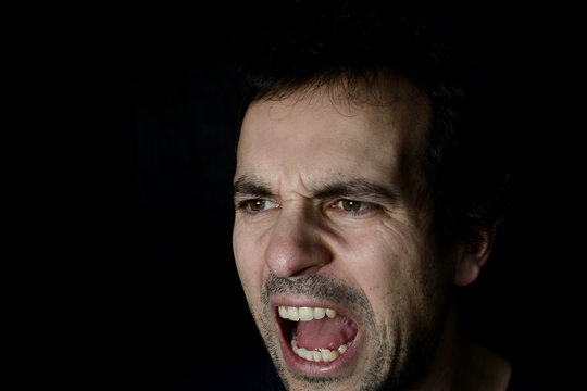 shouting angry young man, black background