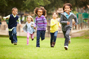 Group Of Young Children Running Towards Camera In Park - Powered by Adobe