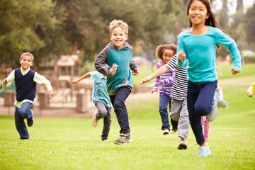 Fototapeta na wymiar Group Of Young Children Running Towards Camera In Park