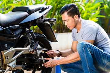 Fototapeta na wymiar Asian man at motorcycle maintenance