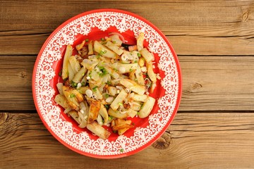 Fried potatoes with scallion in red plate topview copyspace