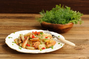 Fried potatoes with scallion and chili in white plate with fork