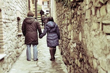 Fototapeta na wymiar couple holding hands in the alley of the village Varzi - Lombardy - Italy