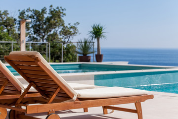 Obraz na płótnie Canvas Luxury swimming pool and deck chair