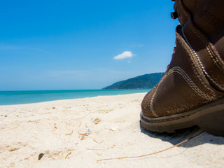Obraz premium Leather shoes sneaker on beach in Thailand Welcome to summer Season in thailand ,Concept Vacation,Holiday,Tourism,Relax,Travel