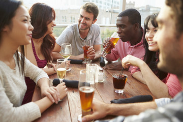 Group Of Friends Enjoying Drink At Outdoor Rooftop Bar