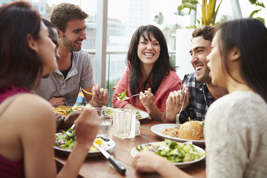 Group Of Friends Enjoying Meal At Rooftop Restaurant