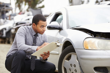 Loss Adjuster Inspecting Car Involved In Accident