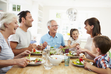 Obraz na płótnie Canvas Multi Generation Family Eating Meal Around Kitchen Table