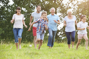 Multi Generation Family Running Across Field Together