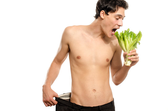 Skinny Young Man Eating An Organic Healthy Salad And Dieting. Green Food For A Healthy Life And A Perfect Diet