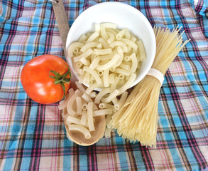 spaghetti, macaroni and tomato on  fabric.