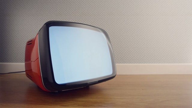 Vintage old television on the floor with static screen, retro wallpaper on background
