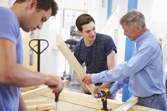 Teacher Helping College Student Studying Carpentry