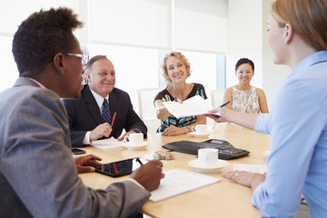 Obraz premium Five Businesspeople Having Meeting In Boardroom