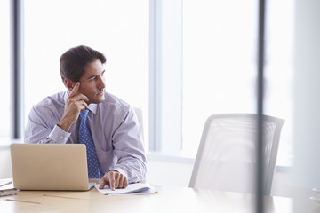 Businessman Working On Laptop At Boardroom Table