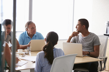 Five Businesspeople Having Meeting In Boardroom