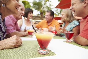 Group Of Senior Friends Enjoying Cocktails In Bar Together
