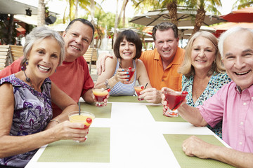 Group Of Senior Friends Enjoying Cocktails In Bar Together