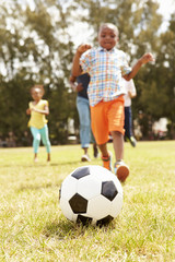 Obraz na płótnie Canvas Family Playing Soccer In Park Together