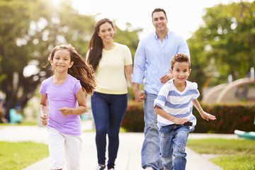 Hispanic Family Walking In Park Together