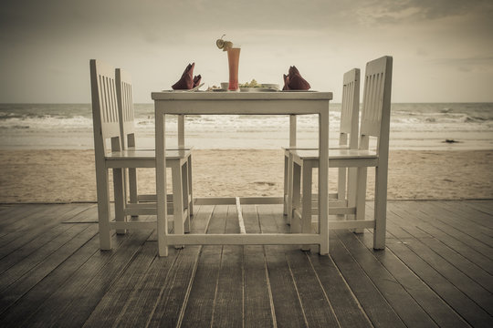 romantic dinner table setup on tropical beach , Vintage style