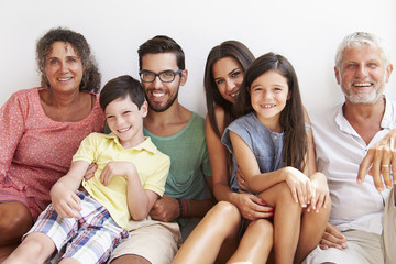 Multi Generation Family Sitting Against Wall