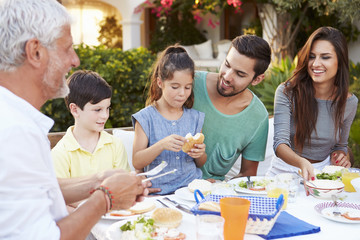 Multi Generation Family Eating Meal At Outdoors Together
