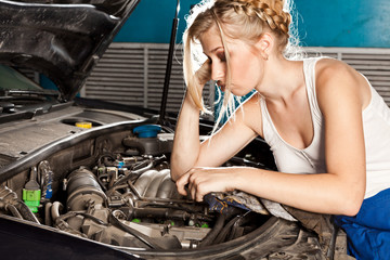 Fototapeta na wymiar Girl tries to repair broken car