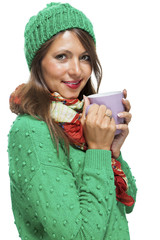 Brünette junge Frau mit großer Kaffeetasse und grüner Wollmü