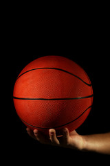 Basketball player holding ball, on dark background