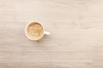 Cup of coffee on wooden table, top view