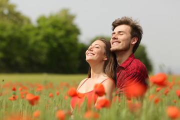 Couple hugging and breathing fresh air in a red field