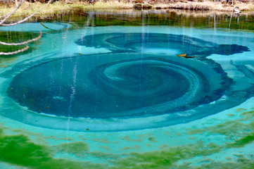 Geyser lake with clear cyan water in Altai mountains