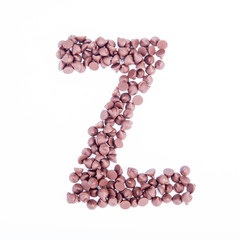 Alphabet from chocolate chips on white background