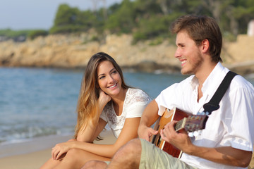 Man flirting playing guitar while a girl looks him amazed
