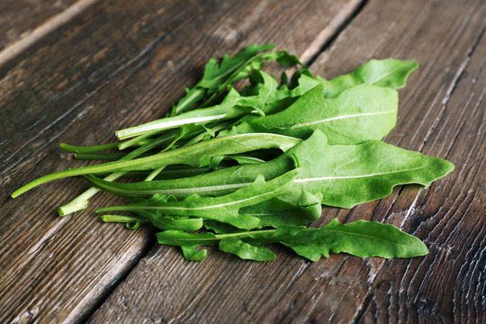 Green arugula leaves on wooden table